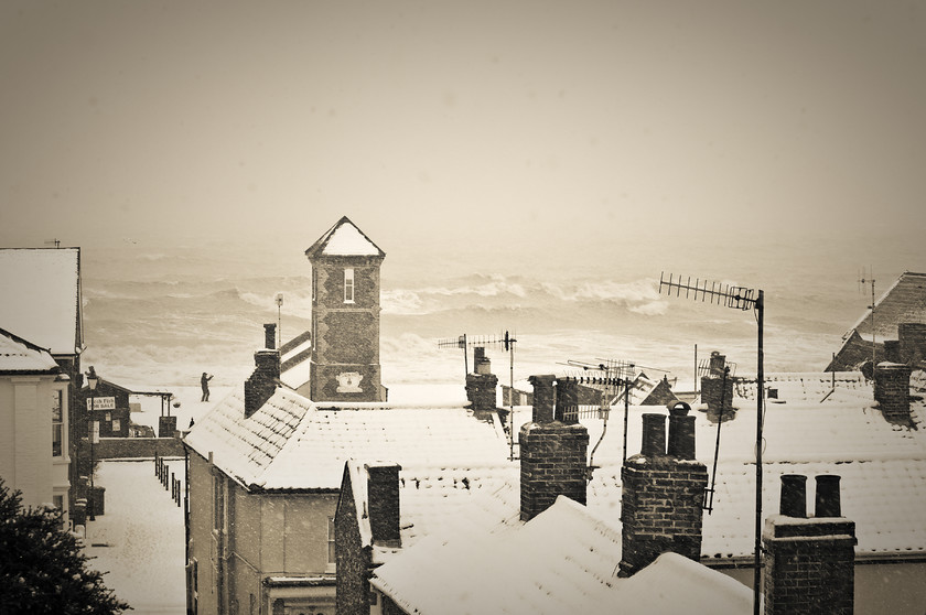 Rooftops at Aldeburgh in winter snow Suffolk-1 
 Rooftops at Aldeburgh in winter snow with rough seas 
 Keywords: Aldeburgh, Gales, Houses, Sea, Snow, Suffolk, Tony Pick, Winter, buildings, nautical, person, roof, solitude, tops, waves